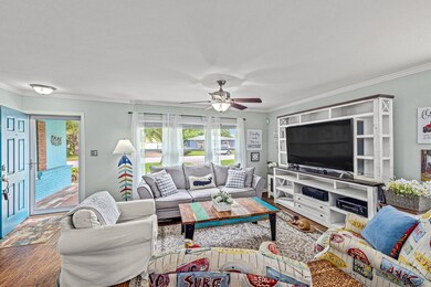 The inviting spacious living room features engineer wood flooring, crown molding, & an abundance of  natural light.