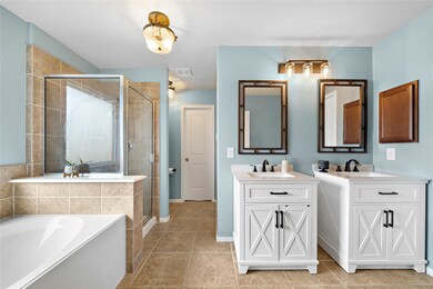 Spacious bathroom for two. Two sinks, one soaker tube, and a stainless glass framed shower.