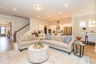 Living room featuring ornamental molding, light wo