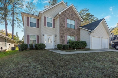 Traditional home with brick siding, a front yard, and concrete driveway