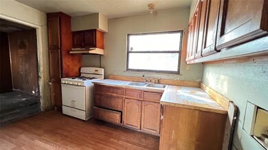 Kitchen with wall chimney range hood, gas range ga