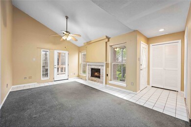 The fireplace is flanked by tall windows allowing