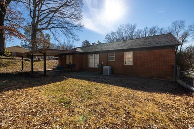 Rear view of house featuring a yard and central AC