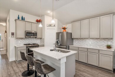 Kitchen has upgraded quartz surfaces and stylish upgraded backsplash