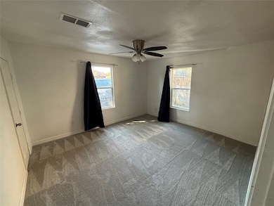 Empty room with carpet flooring and a textured ceiling