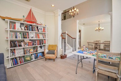 Living room features crown molding and bamboo floors visually connects to foyer and dining room.