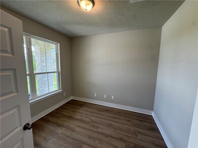 Spare room with a textured ceiling and dark wood-s