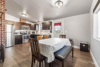 Dining area with dark wood-type flooring and lofted ceiling