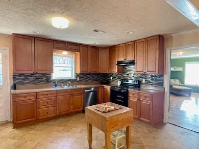 Kitchen featuring dishwasher, a sink, brown cabine