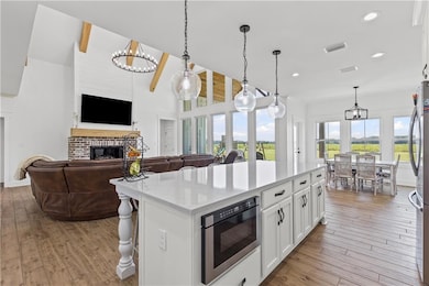 Kitchen featuring a chandelier, pendant lighting, white cabinetry, a breakfast bar, and recessed lighting
