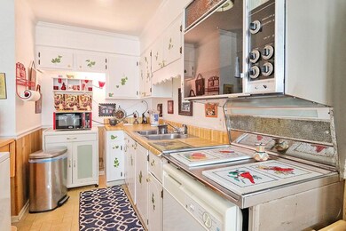Cheerful and bright all-white galley style kitchen. 