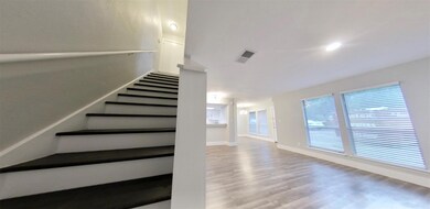 Stairway featuring wood finished floors and recessed lighting
