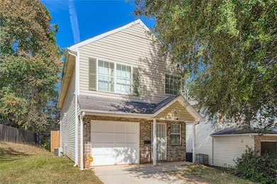 Traditional-style home featuring an attached garage and concrete driveway