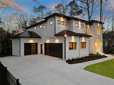 Contemporary house with a standing seam roof, brick siding, driveway, a metal roof, and a garage