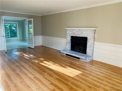 Unfurnished living room featuring crown molding, a brick fireplace, and light hardwood flooring