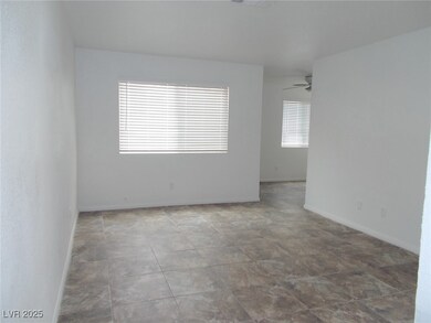 Empty room featuring a ceiling fan and baseboards