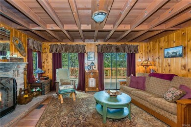 The living room offers rustic charm and a great place for friends to gather in front of the rock fireplace