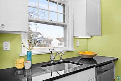 Kitchen with dishwashing machine, white cabinets, 