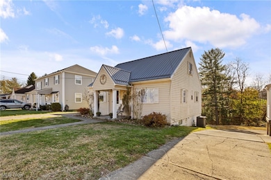 View of front of property featuring a metal roof and a front yard