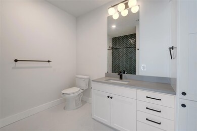 Bathroom with toilet, baseboards, vanity, tile pa