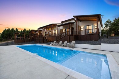 Pool at dusk with a patio and a wooden deck