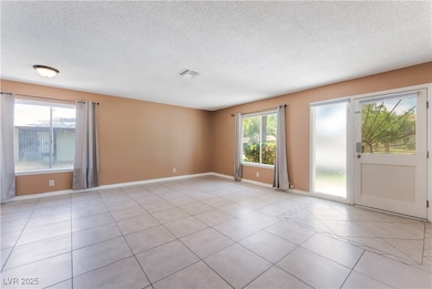 Unfurnished room with a textured ceiling, baseboar
