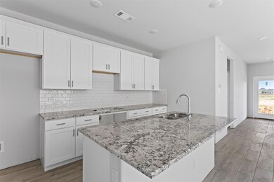 Kitchen featuring sink, white cabinetry, tasteful 