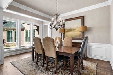 Dining room featuring a notable chandelier, dark h