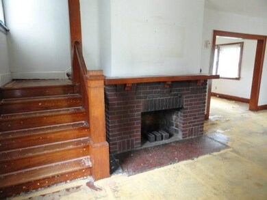 Living room showing the stairway and fireplace