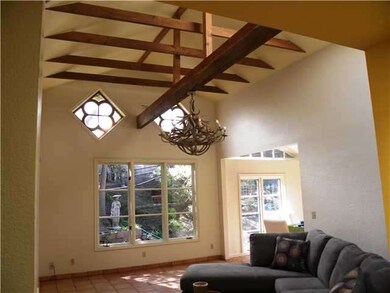 The living room has vaulted beamed ceilings with f