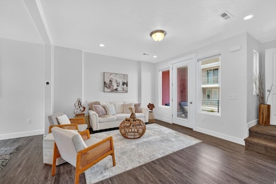Living room featuring dark wood-type flooring, recessed lighting, and a textured ceiling