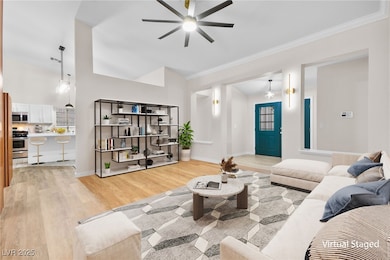 Living area featuring ceiling fan, light wood fini
