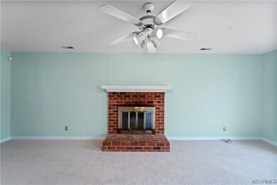 Unfurnished living room with ceiling fan, a fireplace, and light carpet