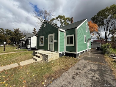 View of front facade with a chimney, a detached garage, a shingled roof, and an outdoor structure