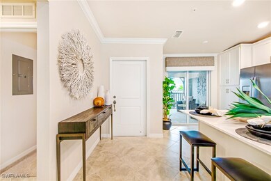 Kitchen featuring stainless steel fridge with ice dispenser, visible vents, electric panel, ornamental molding, and white cabinetry