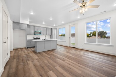 Kitchen featuring gray cabinetry, light wood-style floors, recessed lighting, stainless steel appliances, and a center island with sink