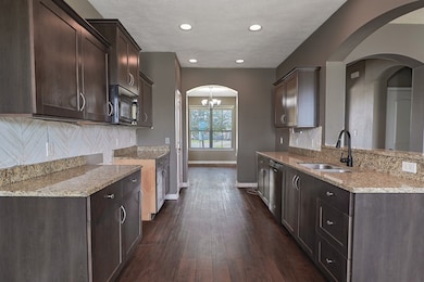 Kitchen featuring tasteful backsplash, sink, dark