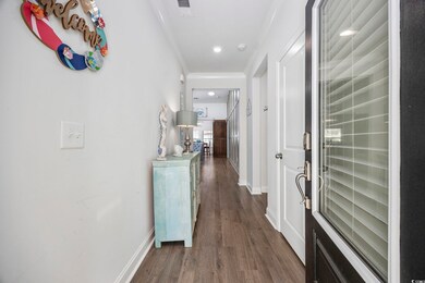 Hallway featuring crown molding and dark wood-type