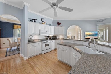 Kitchen featuring white appliances, arched walkway