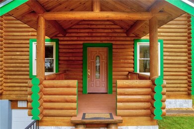 Entrance to property featuring log exterior and crawl space