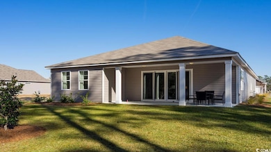 Back of house with a yard and a patio