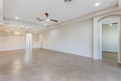 Empty room featuring ceiling fan, light tile patte