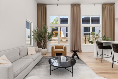 Living area featuring light wood finished floors and a high ceiling