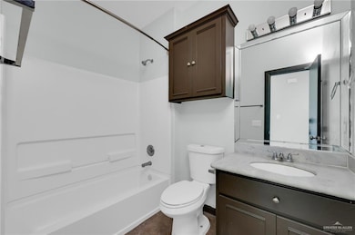 Full bath with toilet, vanity, and shower / washtub combination