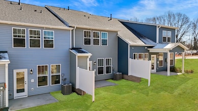 Townhome exterior with craftsman design, large windows, garage, two car parking pad, and blue siding at Aspen Ridge in Lyman