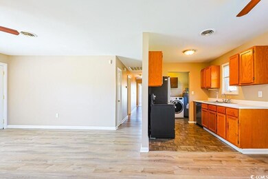 Kitchen with ceiling fan, light countertops, brown cabinets, and light wood-style floors
