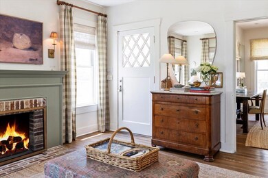 Foyer with a brick fireplace, wood finished floor