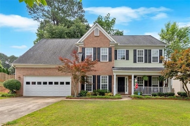 View of front facade featuring brick siding, a porch, a front lawn, and concrete driveway