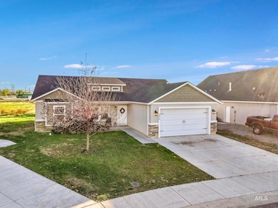 View of front of house with stone siding, a front yard, concrete driveway, and an attached garage