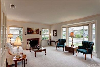 Living Room with crown molding, wood burning firep